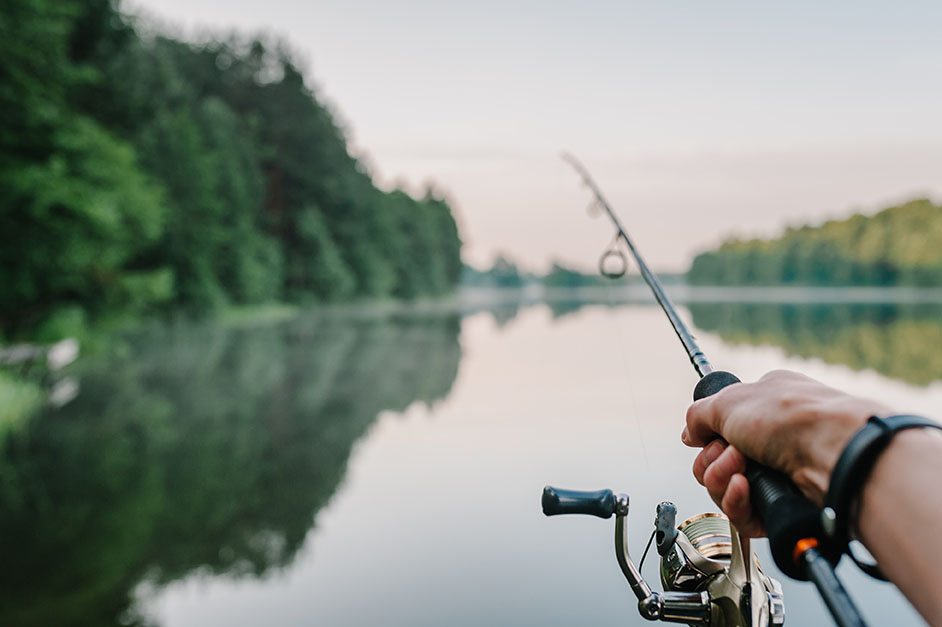 Fisherman,With,Rod,,Spinning,Reel,On,The,River,Bank.,Sunrise.